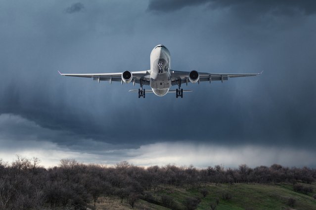 White passenger airplane is flying in the sky with clouds